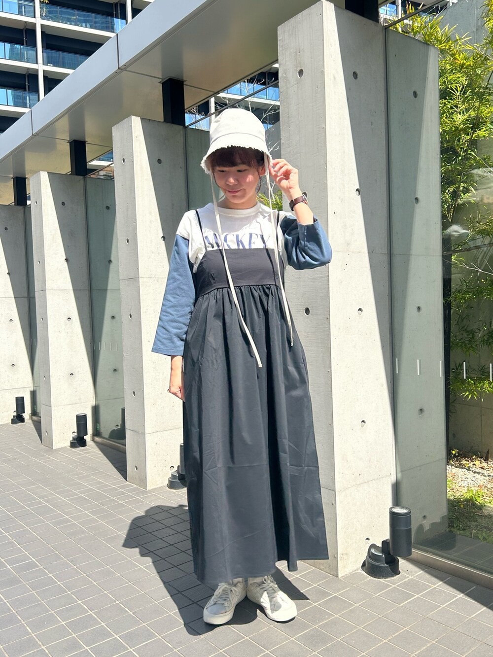 ホワイト系のショルダーバッグ、ホワイト系のTシャツ/カットソー、ブラック系のワンピースを着用したレディースの春コーディネートの2枚目の写真