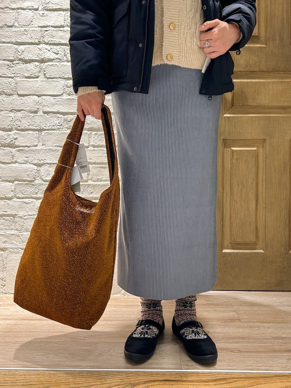 ブルー系のダウンジャケット/コート、ブルー系のスカート、ホワイト系のカーディガン/ボレロを着用したレディースの冬コーディネートの3枚目の写真