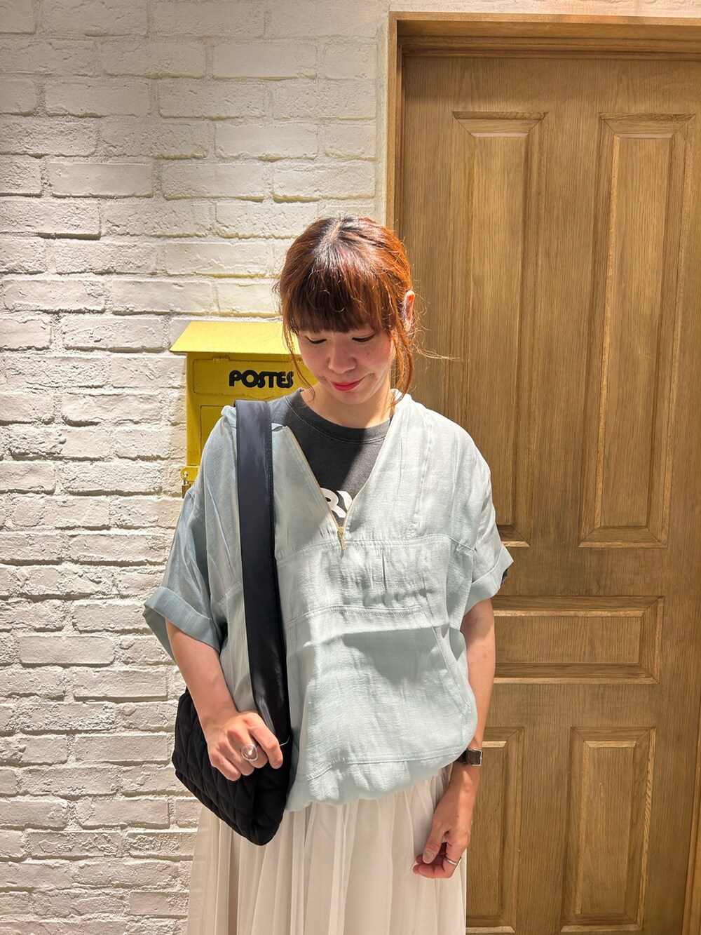 グレー系のTシャツ/カットソー、ブルー系のブルゾン、ホワイト系のスカートを着用したレディースの夏コーディネートの2枚目の写真