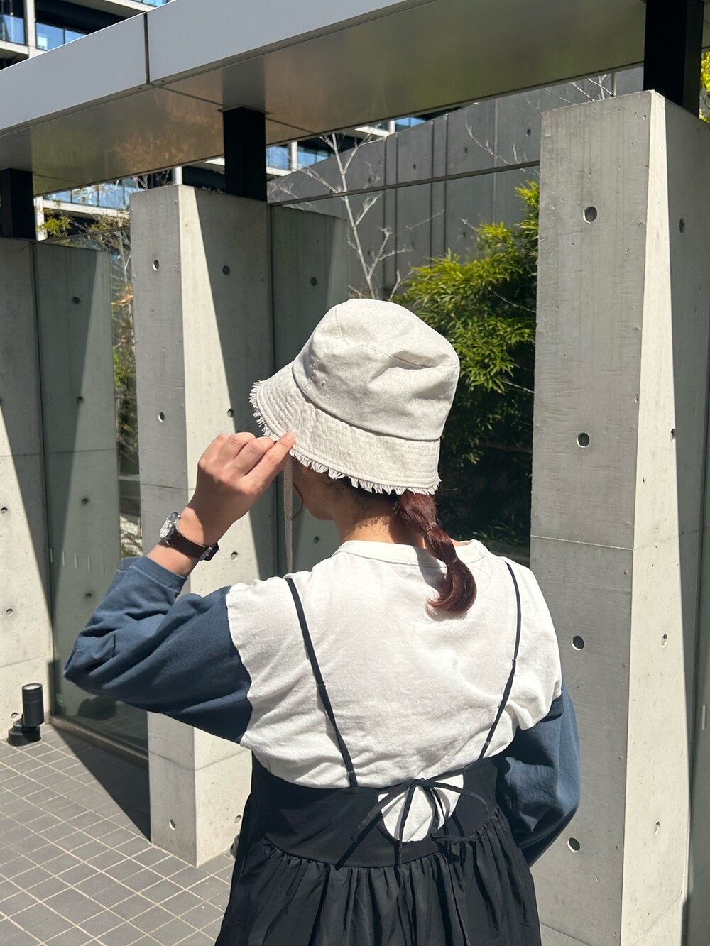 ホワイト系のショルダーバッグ、ホワイト系のTシャツ/カットソー、ブラック系のワンピースを着用したレディースの春コーディネートの3枚目の写真