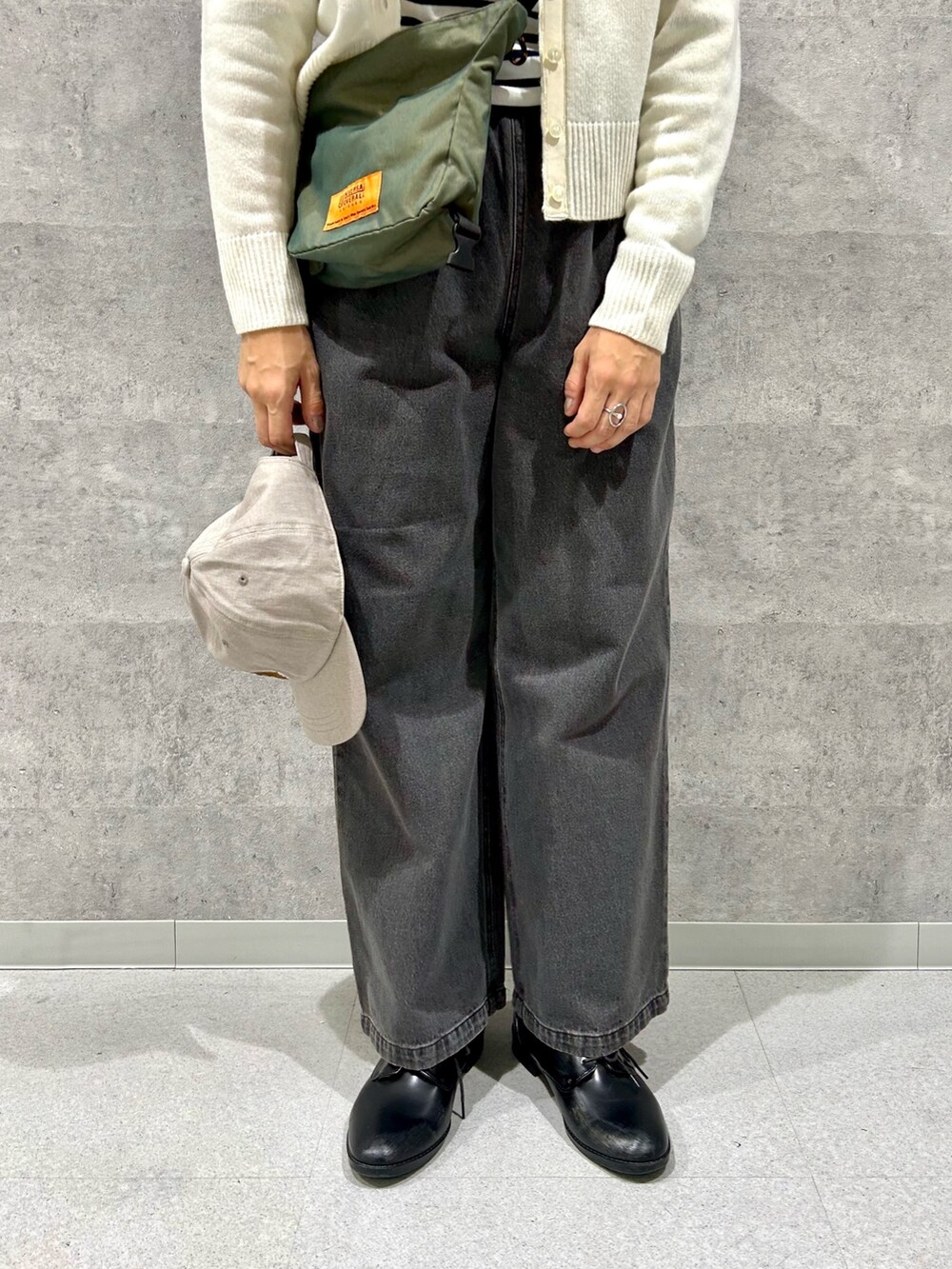 グレー系のデニムパンツ、グリーン系のショルダーバッグ、ブルー系のTシャツ/カットソーを着用したレディースの秋コーディネートの3枚目の写真