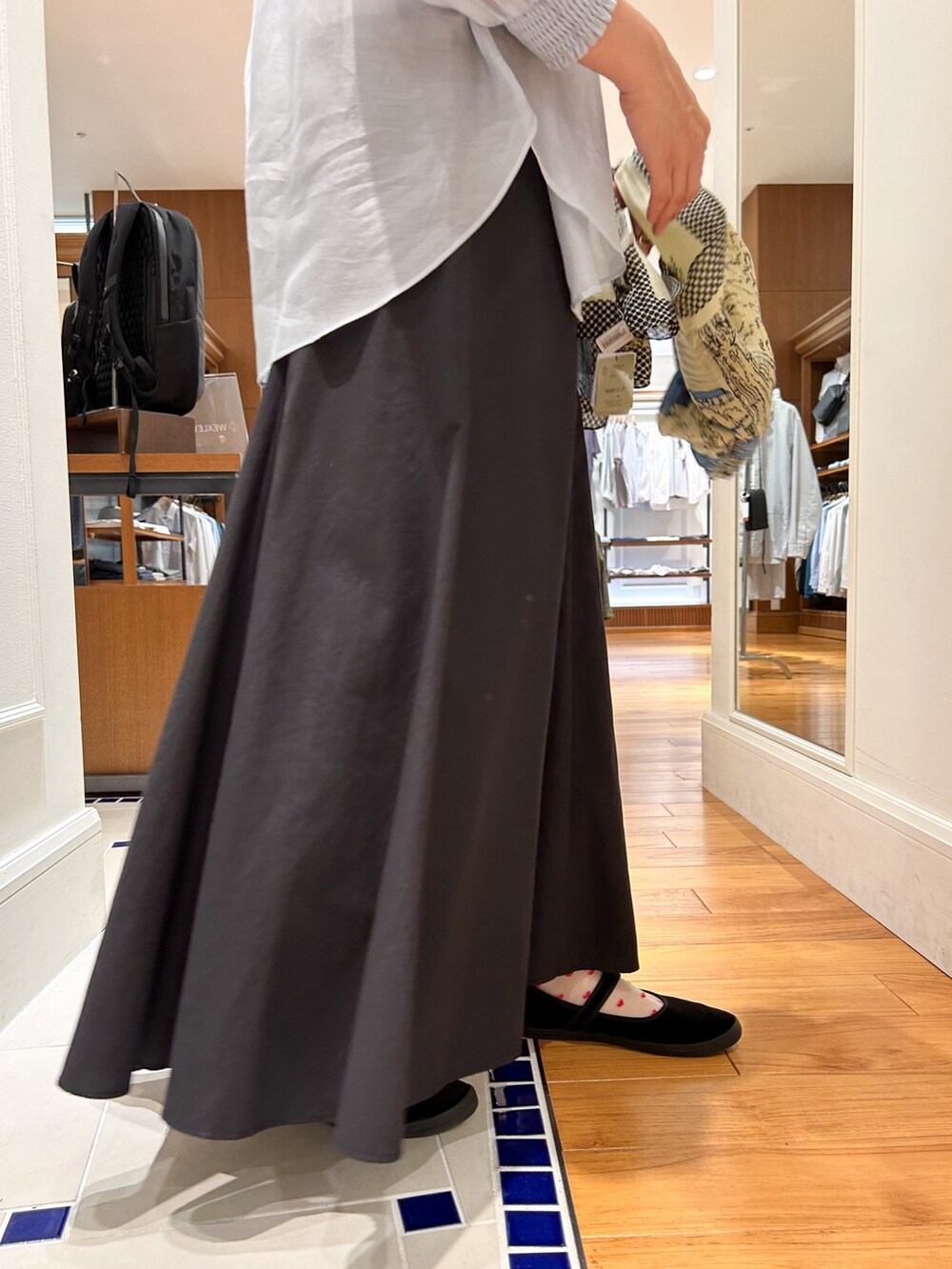 ブラック系のスカート、ホワイト系のTシャツ/カットソー、ブルー系のシャツ/ブラウスを着用したレディースの春コーディネートの3枚目の写真