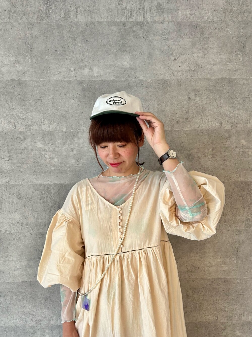ホワイト系のワンピース、グリーン系のTシャツ/カットソー、グリーン系のショルダーバッグを着用したレディースの春コーディネートの2枚目の写真