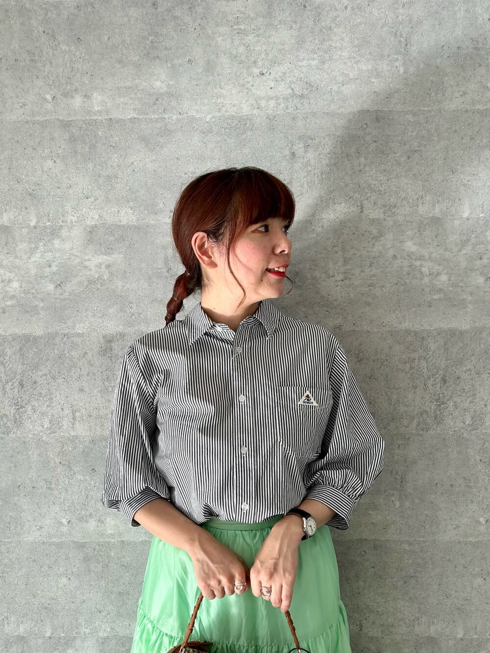 ブラック系のシャツ/ブラウス、グリーン系のスカート、イエロー系のショルダーバッグを着用したレディースの春コーディネートの2枚目の写真