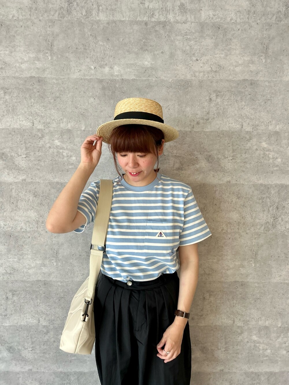 ホワイト系のショルダーバッグ、ブルー系のTシャツ/カットソー、ブラック系のスニーカーを着用したレディースの春コーディネートの2枚目の写真