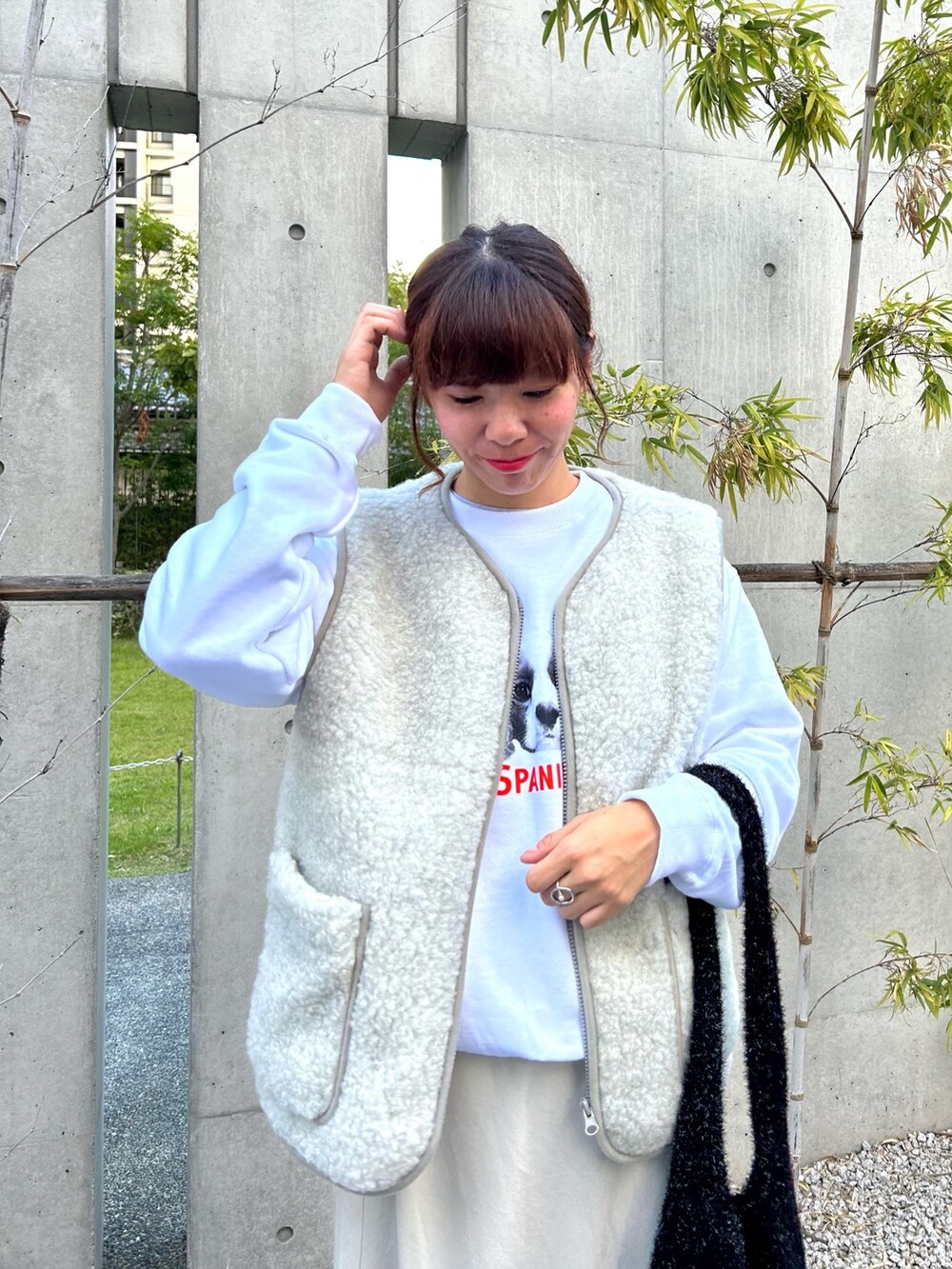 グレー系のブルゾン、ホワイト系のスウェット、ブラック系のトートバッグを着用したレディースの秋コーディネートの2枚目の写真