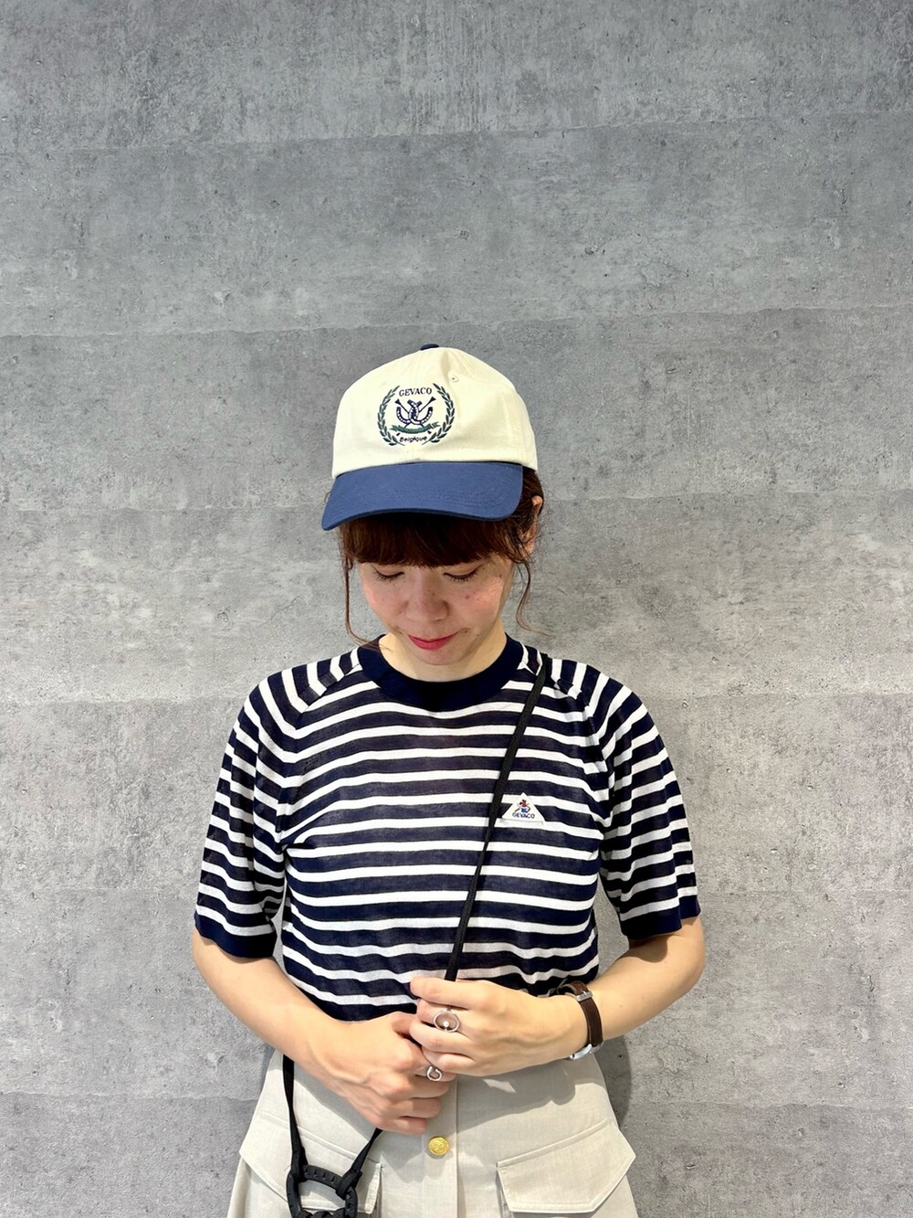 ブルー系のTシャツ/カットソー、ベージュ系のショルダーバッグ、ベージュ系のスカートを着用したレディースの春コーディネートの2枚目の写真