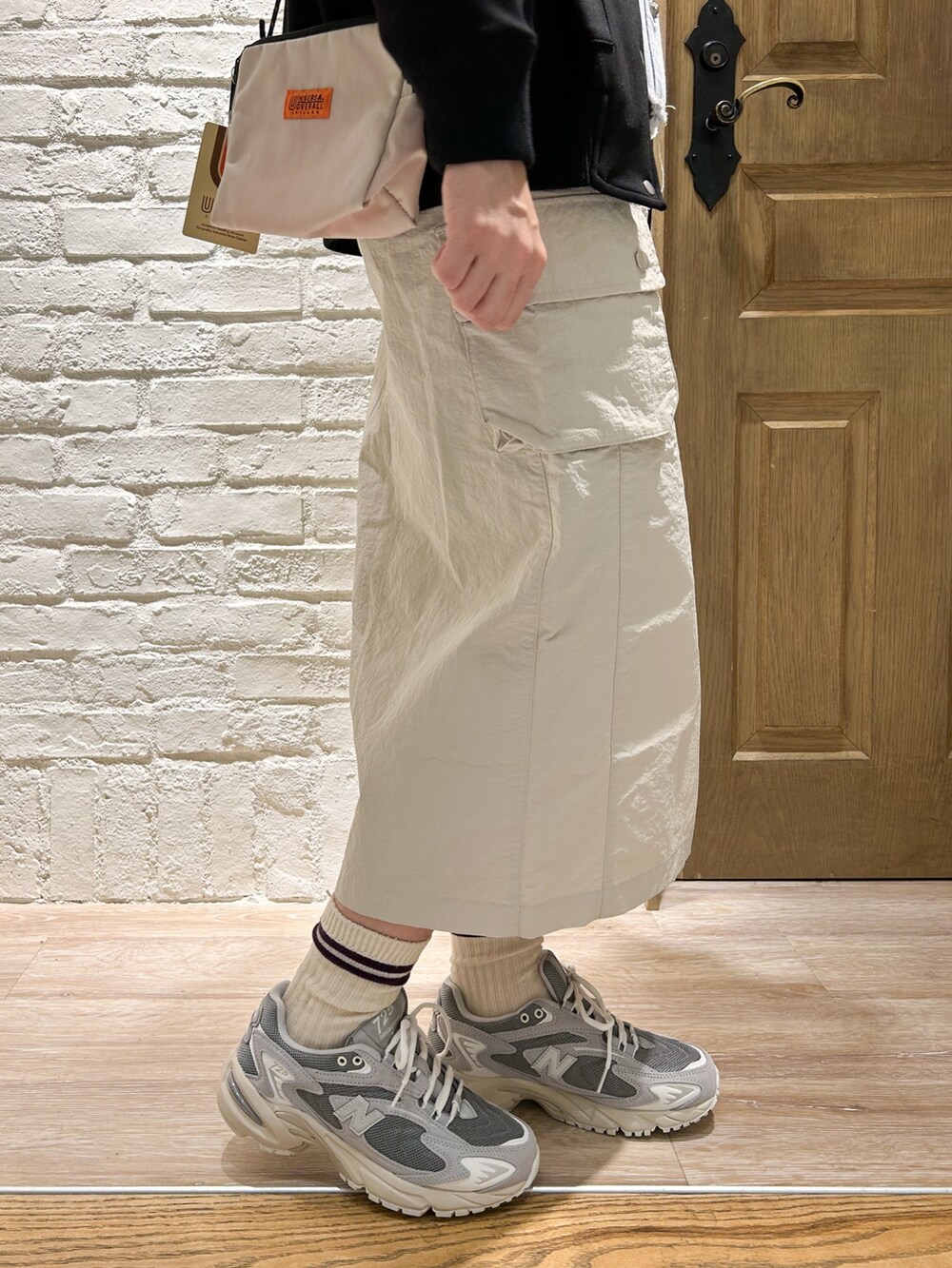 ブラック系のブルゾン、ブルー系のシャツ/ブラウス、ベージュ系のスカートを着用したレディースの春コーディネートの3枚目の写真