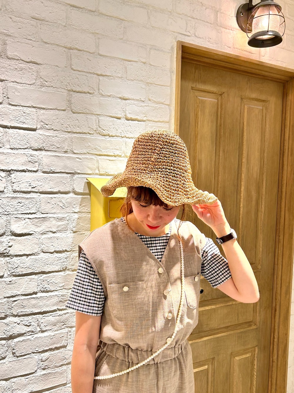 ブラック系のかごバッグ、ホワイト系のTシャツ/カットソー、ベージュ系のつなぎ/オールインワンを着用したレディースの夏コーディネートの2枚目の写真