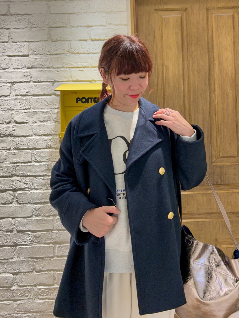 ブルー系のピーコート、グレー系のスウェット、その他のショルダーバッグを着用したレディースの秋コーディネートの2枚目の写真