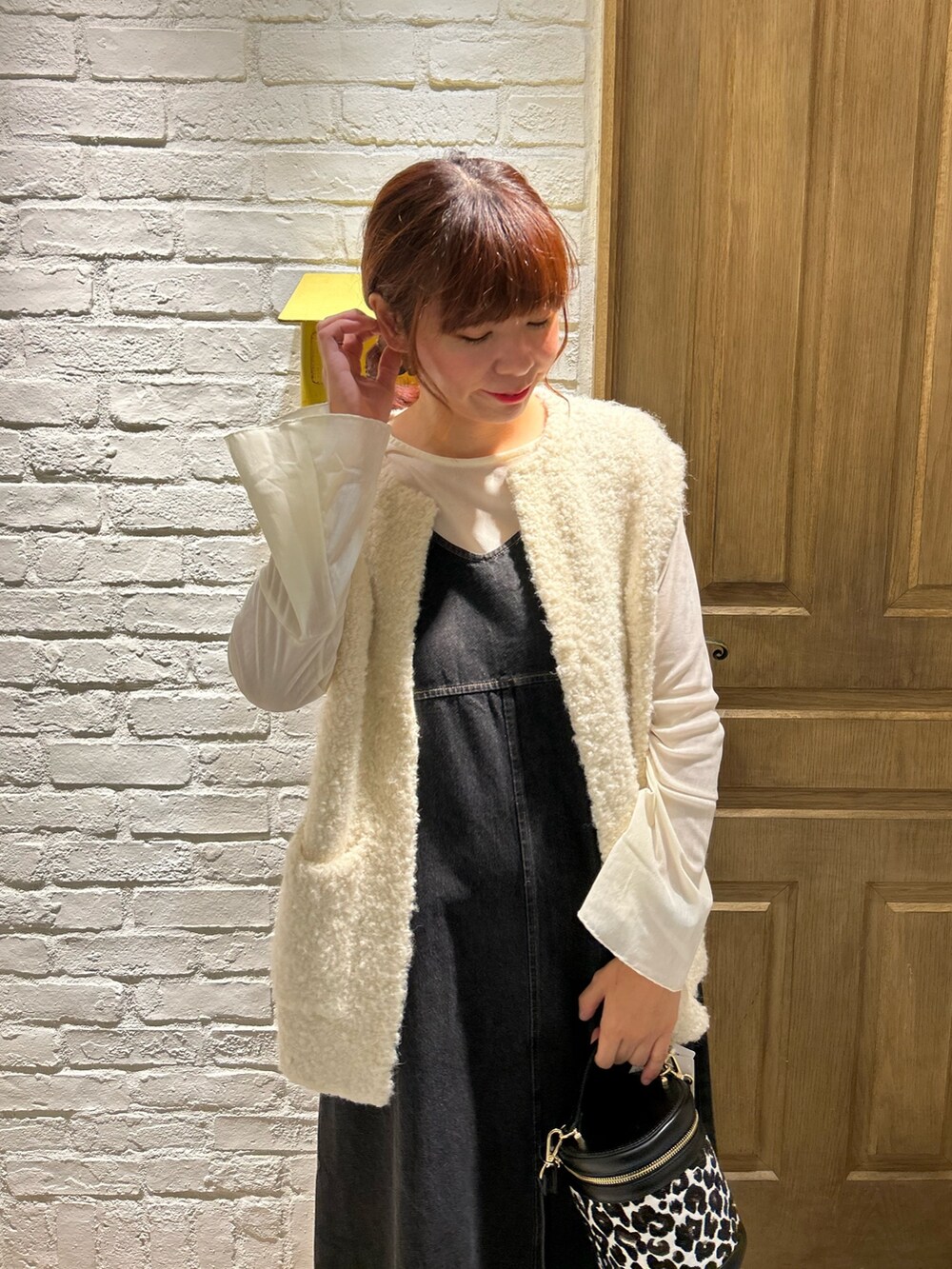 ホワイト系のベスト、ホワイト系のTシャツ/カットソー、ブラック系のワンピースを着用したレディースの秋コーディネートの2枚目の写真