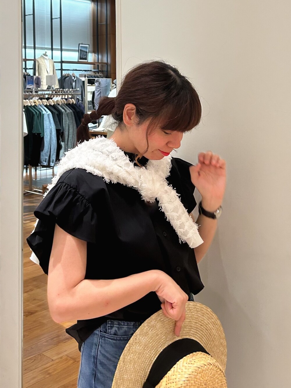 ブルー系のデニムパンツ、ブラック系のシャツ/ブラウス、ホワイト系のカーディガン/ボレロを着用したレディースの春コーディネートの3枚目の写真