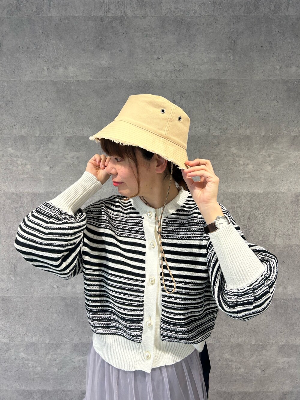 ブルー系のカーディガン/ボレロ、ベージュ系のスカート、ホワイト系のショルダーバッグを着用したレディースの冬コーディネートの2枚目の写真