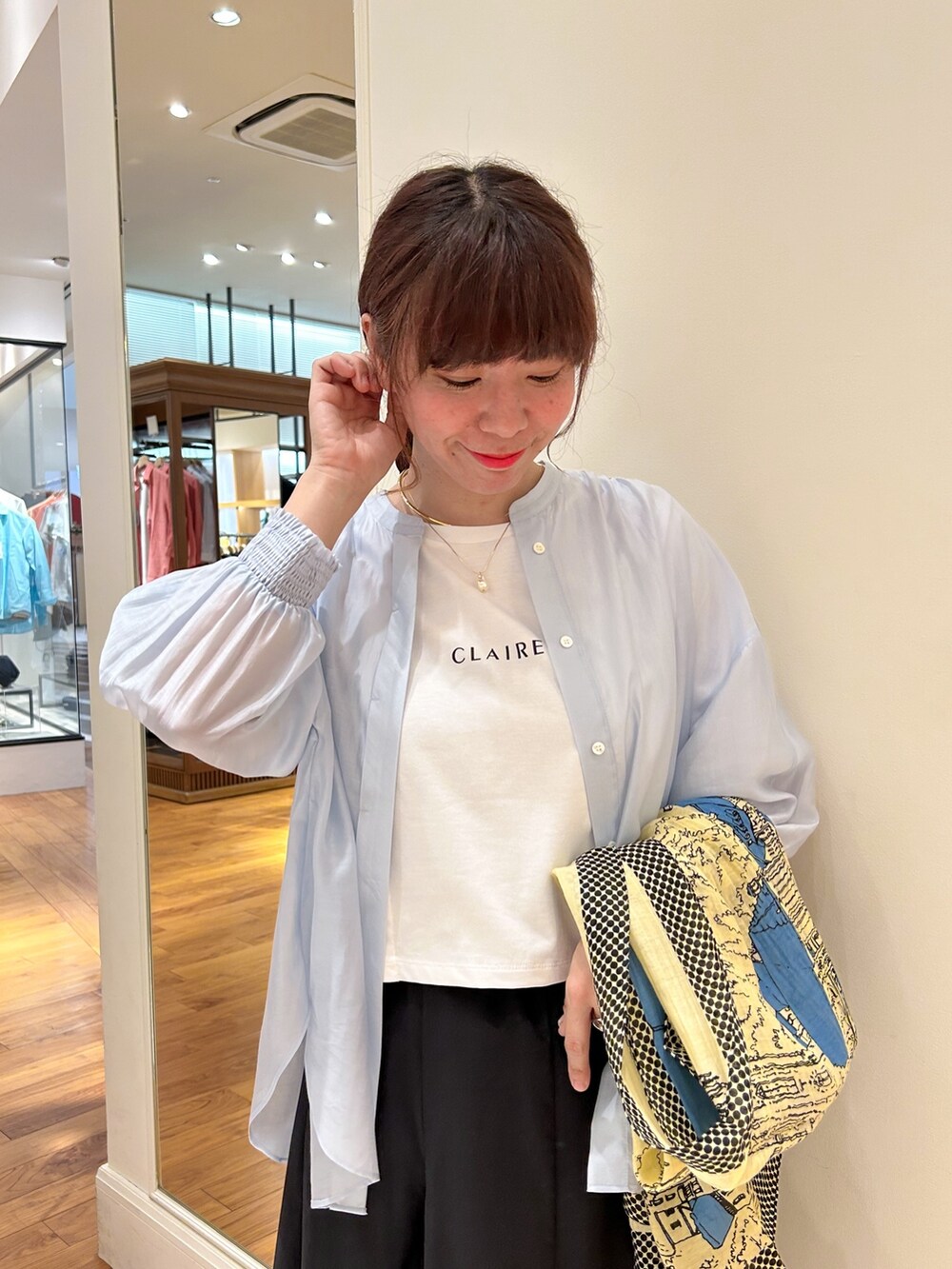 ブラック系のスカート、ホワイト系のTシャツ/カットソー、ブルー系のシャツ/ブラウスを着用したレディースの春コーディネートの2枚目の写真