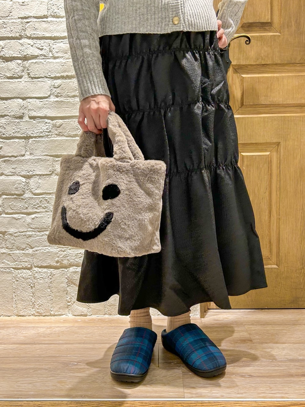 グレー系のカーディガン/ボレロ、グリーン系のダウンジャケット/コート、ブラック系のスカートを着用したレディースの冬コーディネートの3枚目の写真