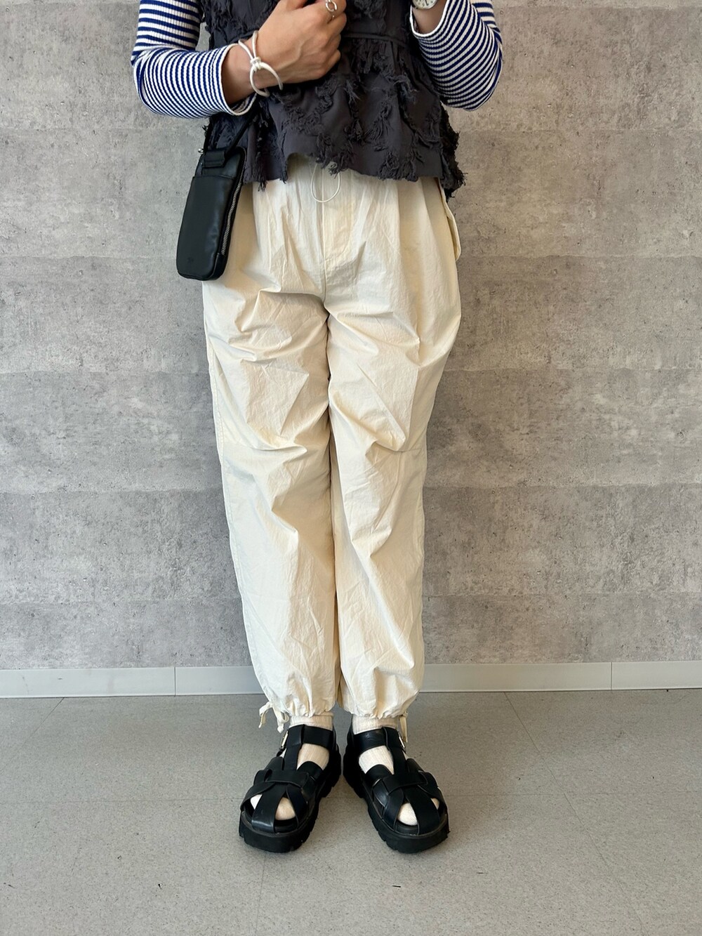 ブラック系のショルダーバッグ、ホワイト系のその他パンツ、グレー系のシャツ/ブラウスを着用したレディースの春コーディネートの3枚目の写真