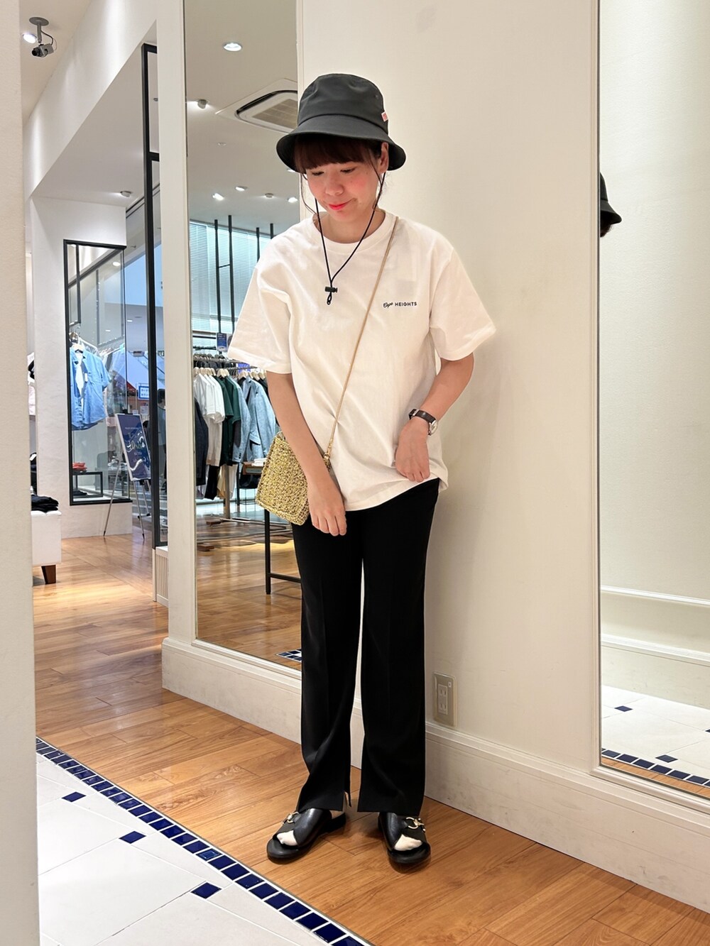 ホワイト系のTシャツ/カットソー、ゴールド系のショルダーバッグ、ブラック系のその他パンツを着用したレディースの春コーディネートの2枚目の写真