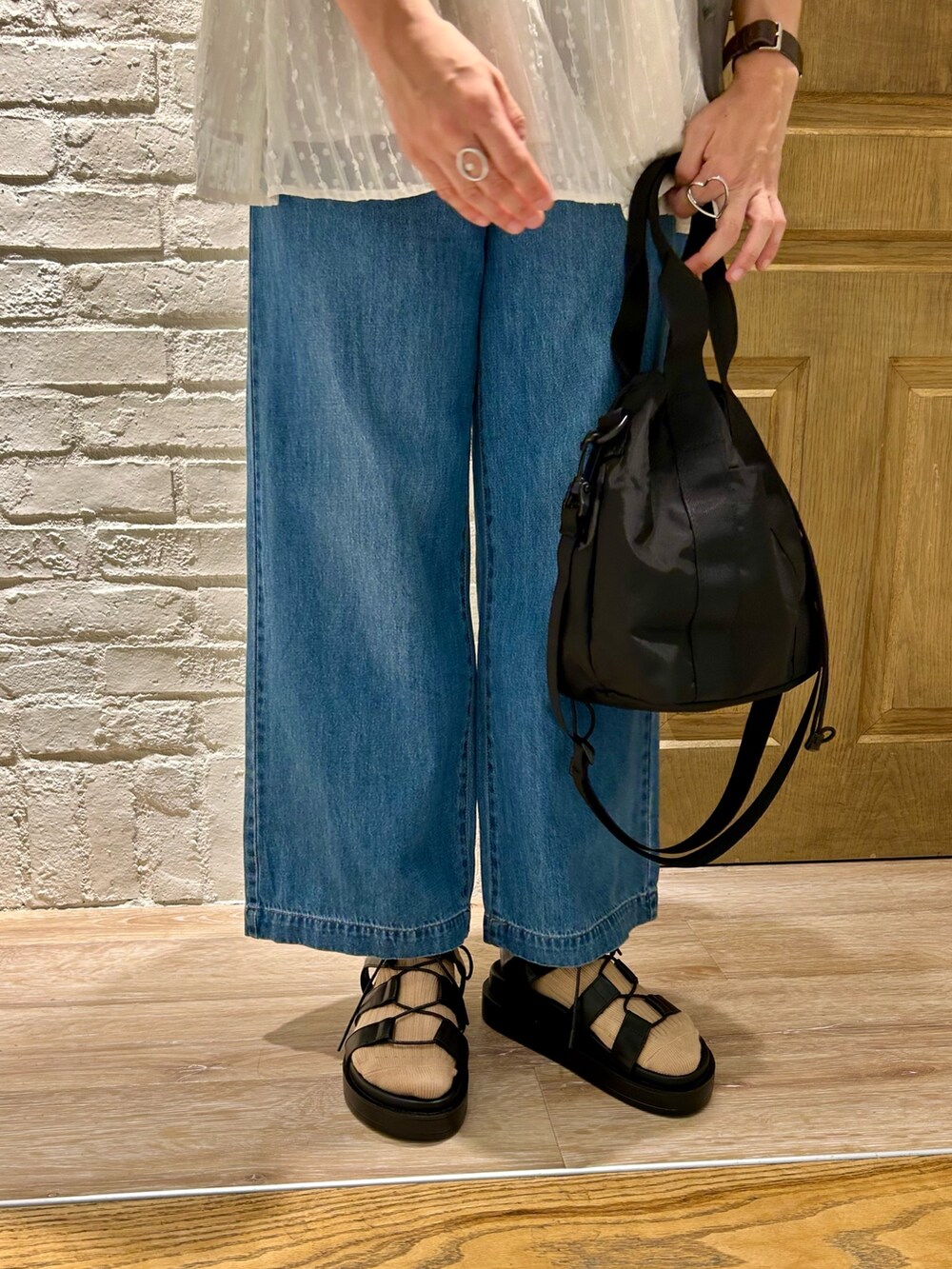 ホワイト系のシャツ/ブラウス、グレー系のTシャツ/カットソー、ブルー系のデニムパンツを着用したレディースの夏コーディネートの3枚目の写真