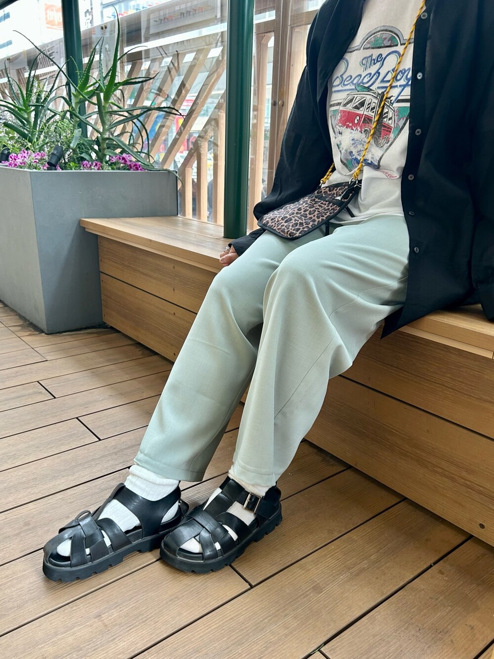 グリーン系のスラックス、ホワイト系のTシャツ/カットソー、ブラック系のシャツ/ブラウスを着用したレディースの春コーディネートの4枚目の写真