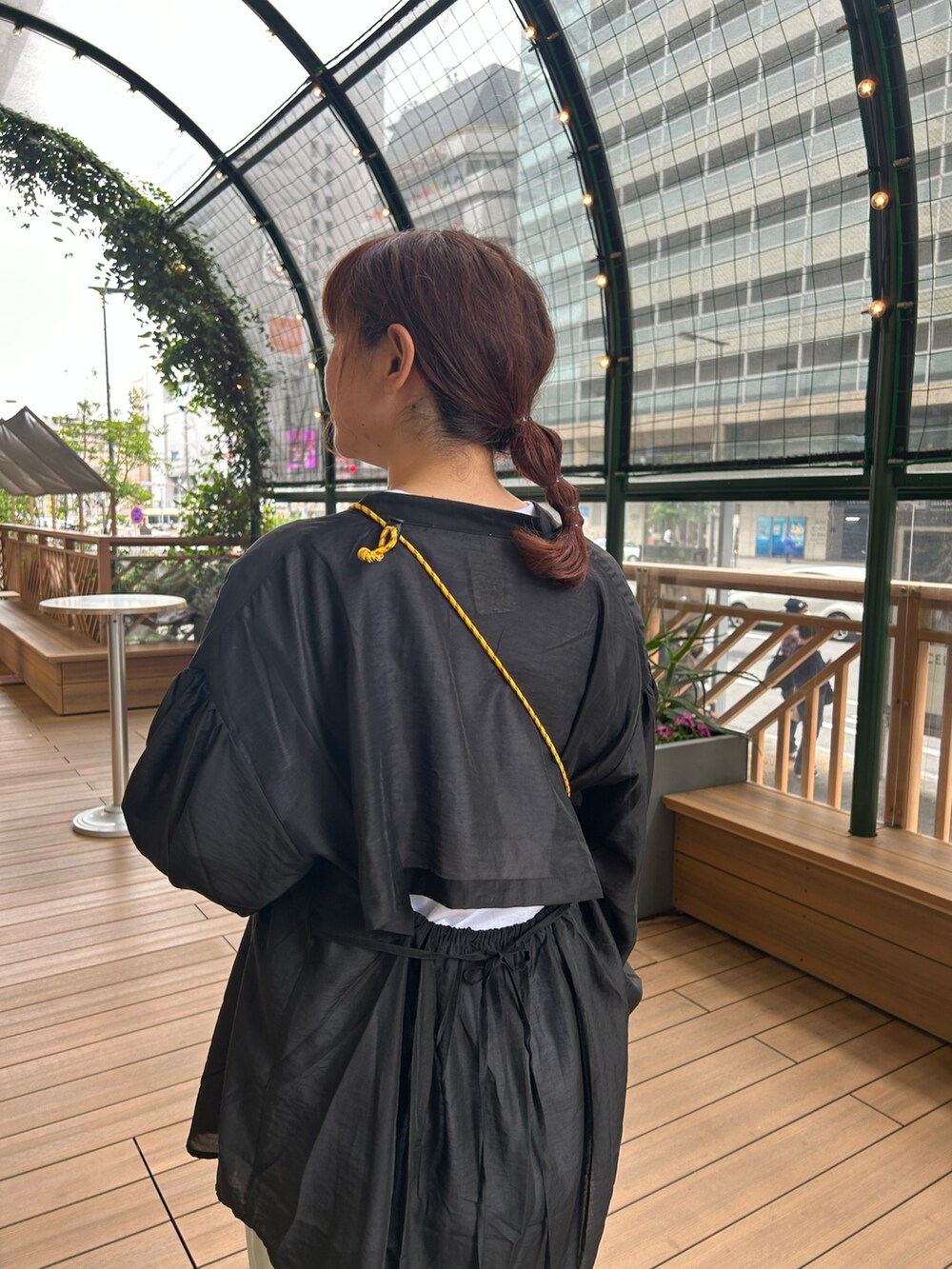 グリーン系のスラックス、ホワイト系のTシャツ/カットソー、ブラック系のシャツ/ブラウスを着用したレディースの春コーディネートの3枚目の写真