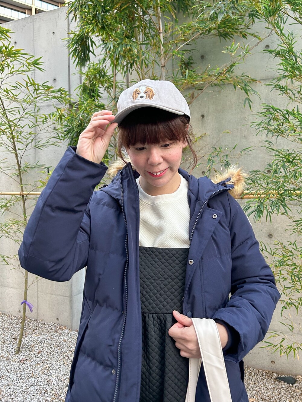 ブルー系のダウンジャケット/コート、ホワイト系のTシャツ/カットソー、ブラック系のワンピースを着用したレディースの冬コーディネートの2枚目の写真