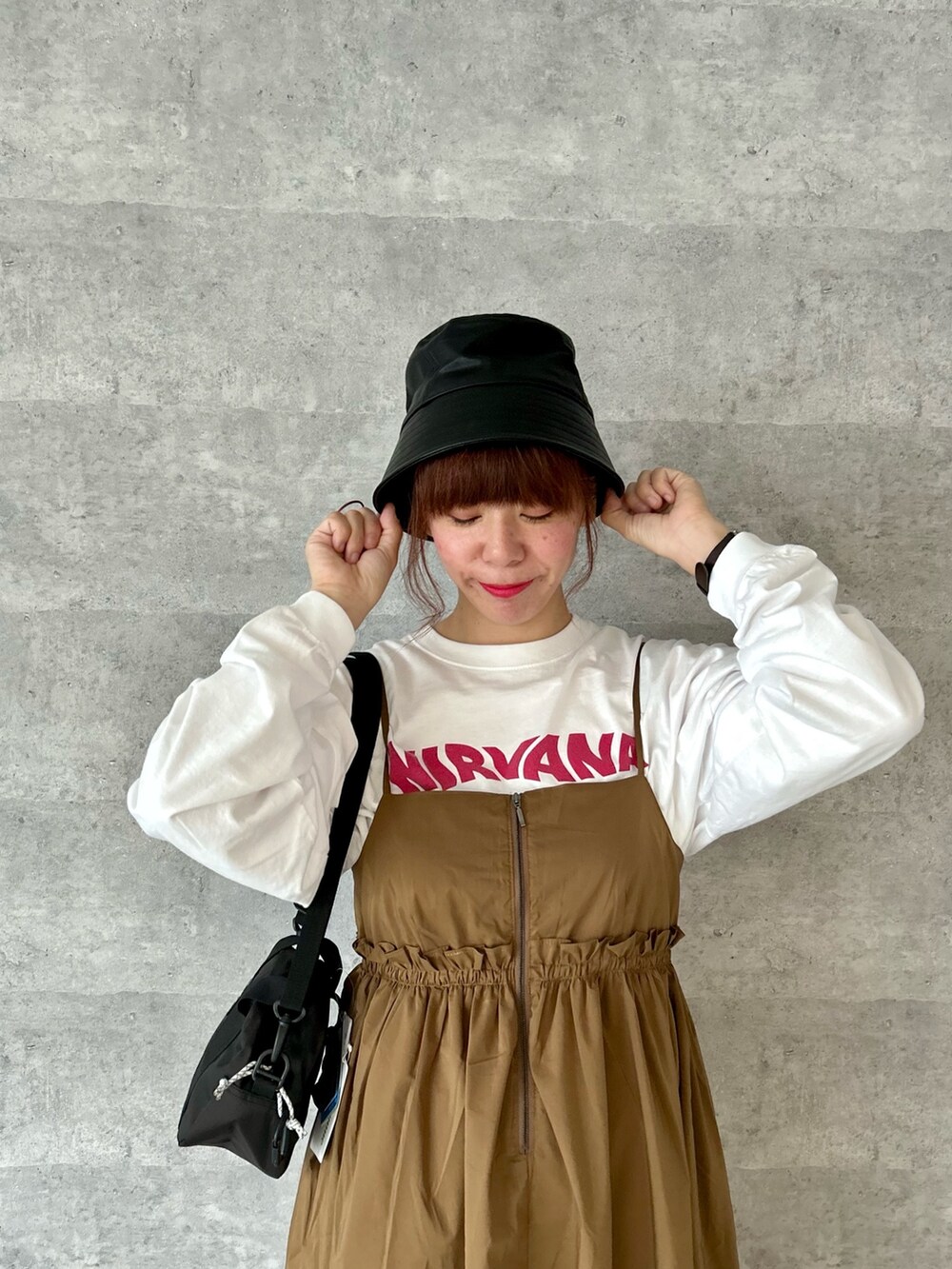 ブラック系のショルダーバッグ、イエロー系のワンピース、ホワイト系のTシャツ/カットソーを着用したレディースの秋コーディネートの2枚目の写真