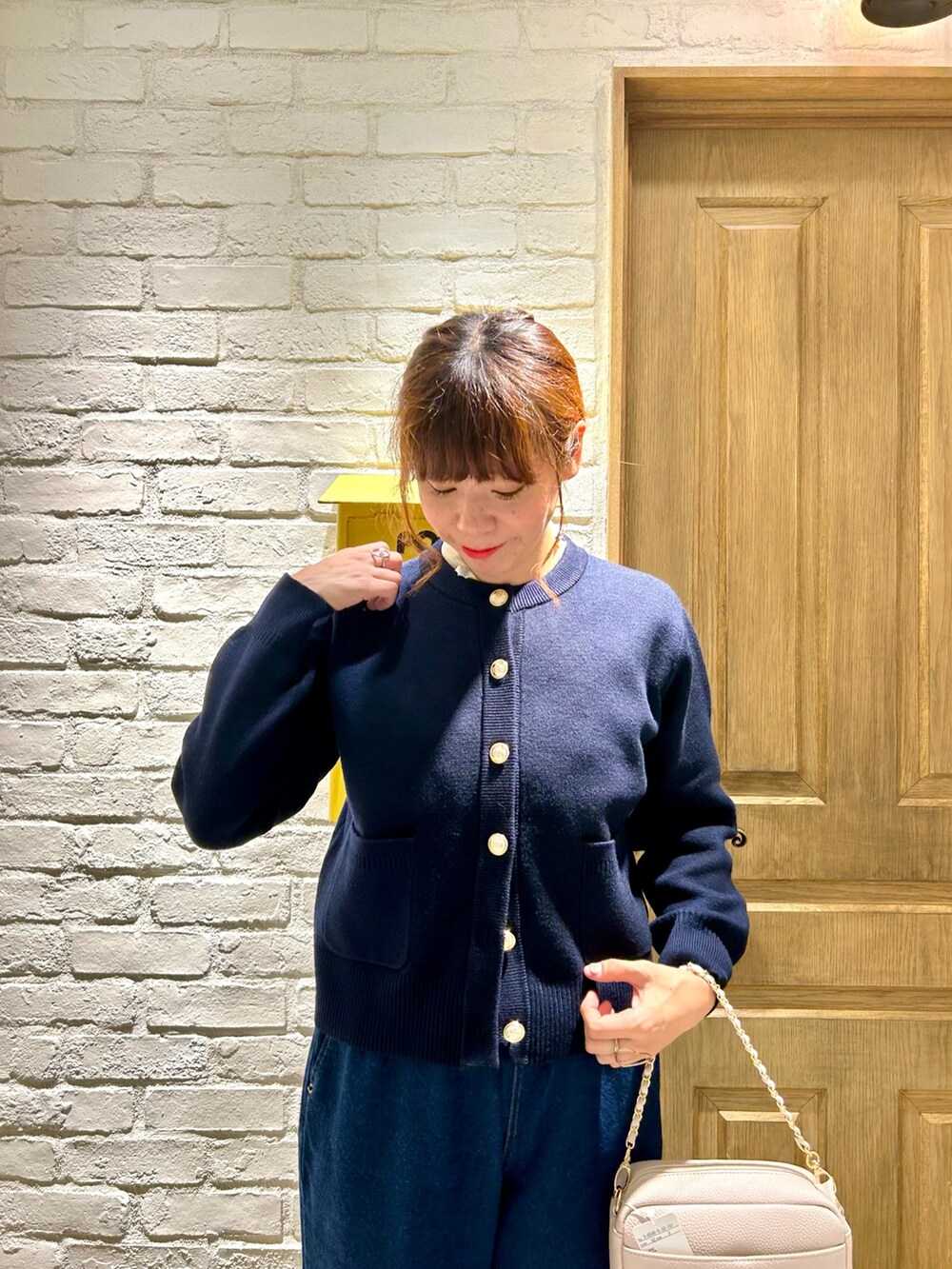 ブルー系のデニムパンツ、ブルー系のカーディガン/ボレロ、ホワイト系のシャツ/ブラウスを着用したレディースの秋コーディネートの3枚目の写真