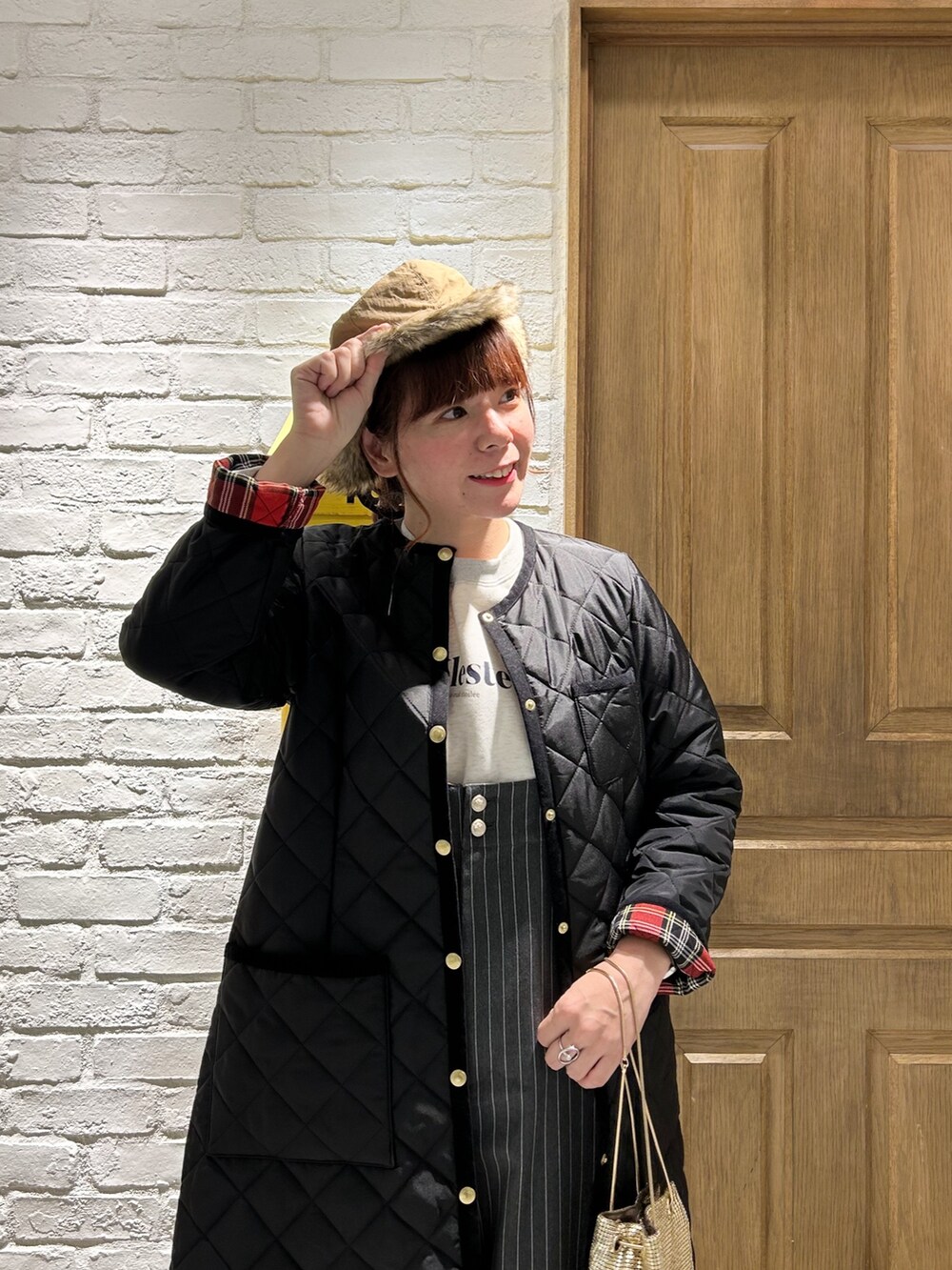 ブラック系のサロペット/オーバーオール、ホワイト系のスウェット、ブラック系のその他アウターを着用したレディースの冬コーディネートの2枚目の写真