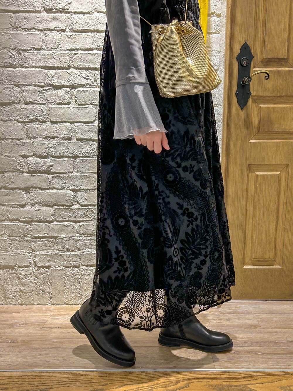 グレー系のTシャツ/カットソー、ブラック系のワンピース、ゴールド系のショルダーバッグを着用したレディースの秋コーディネートの3枚目の写真