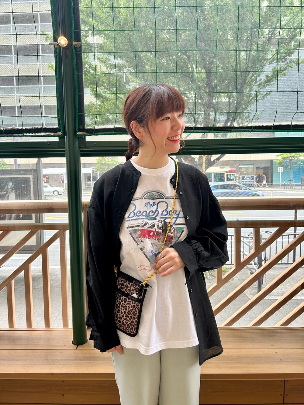 グリーン系のスラックス、ホワイト系のTシャツ/カットソー、ブラック系のシャツ/ブラウスを着用したレディースの春コーディネートの2枚目の写真