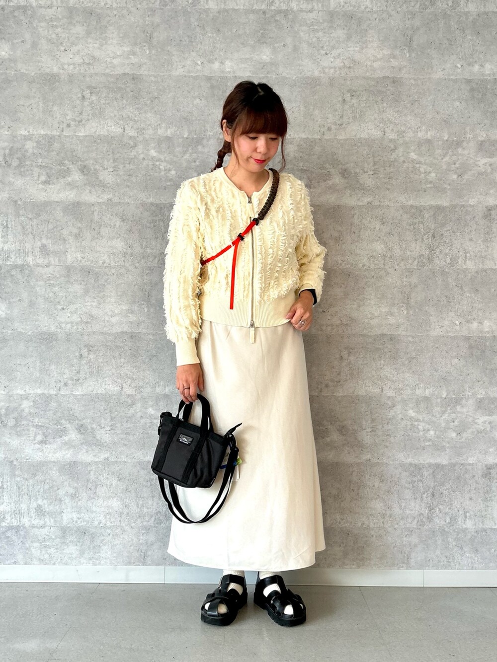 ベージュ系のスカート、ホワイト系のカーディガン/ボレロ、ブルー系のデニムジャケットを着用したレディースの秋コーディネートの3枚目の写真