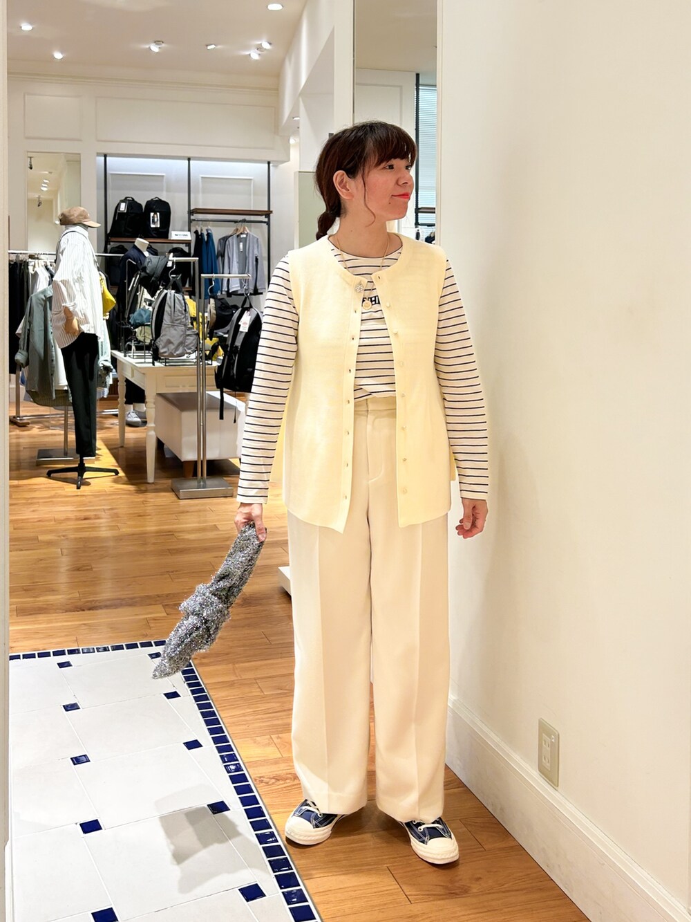 ホワイト系のベスト、ブラック系のバックパック/リュック、ホワイト系のその他パンツを着用したレディースの秋コーディネートの2枚目の写真