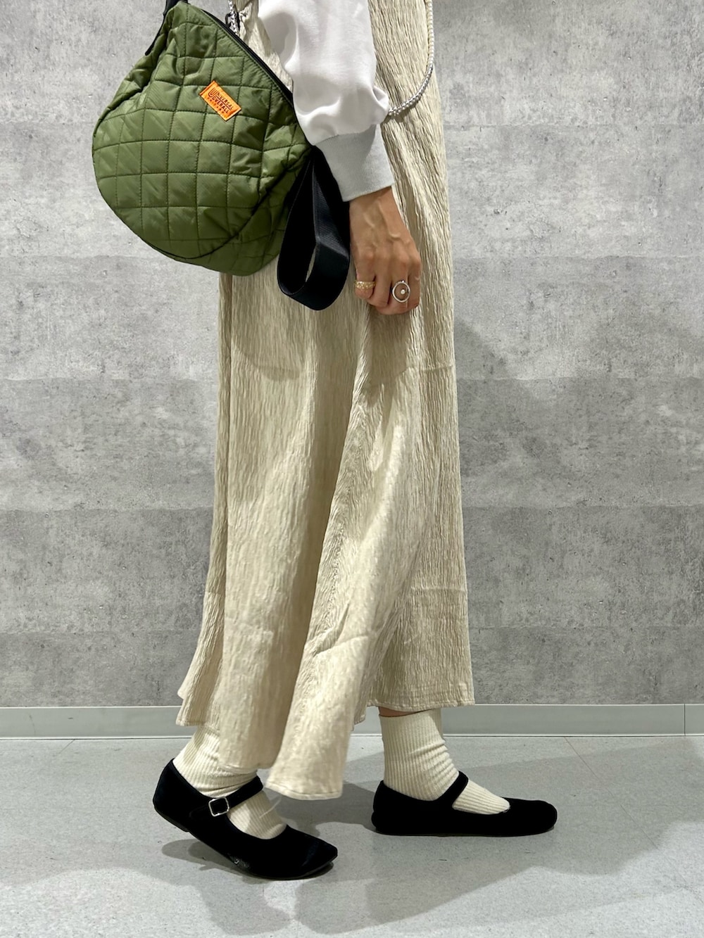 グレー系のシャツ/ブラウス、ブラック系のダウンジャケット/コート、ベージュ系のワンピースを着用したレディースの秋コーディネートの3枚目の写真