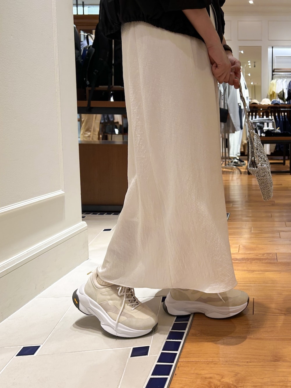 ブラック系のブルゾン、ブラック系のTシャツ/カットソー、ホワイト系のワンピースを着用したレディースの春コーディネートの3枚目の写真