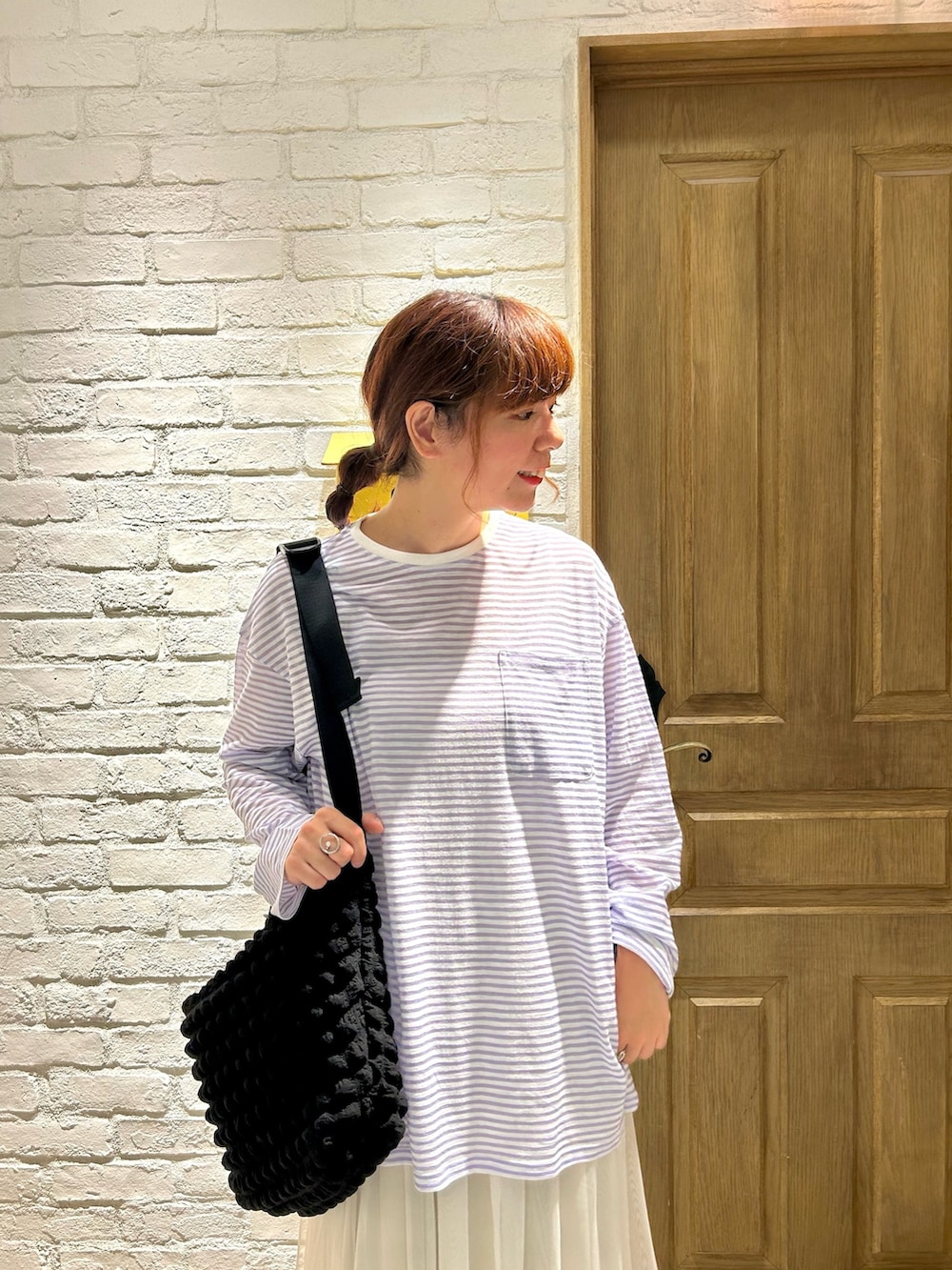 ブルー系のデニムパンツ、ブラック系のサンダル、ブルー系のTシャツ/カットソーを着用したレディースの夏コーディネートの2枚目の写真