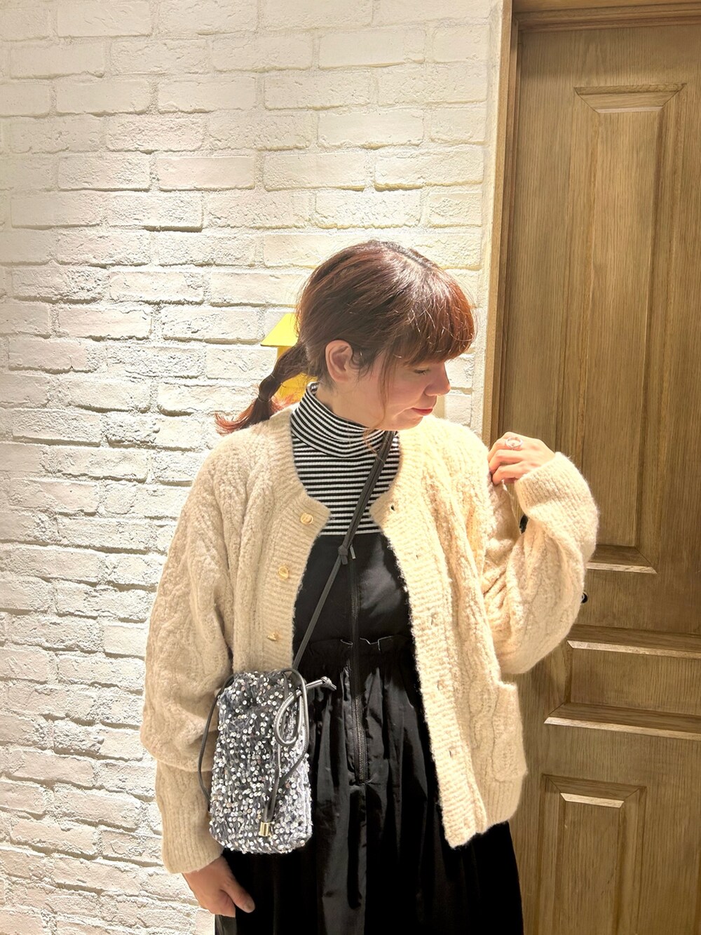 ホワイト系のカーディガン/ボレロ、ホワイト系のTシャツ/カットソー、ブラック系のワンピースを着用したレディースの秋コーディネートの2枚目の写真