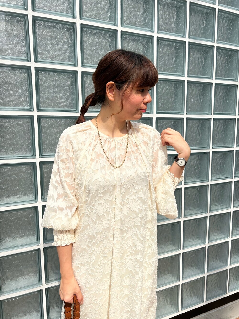 ホワイト系のワンピース、イエロー系のショルダーバッグ、ゴールド系のネックレスを着用したレディースの春コーディネートの2枚目の写真