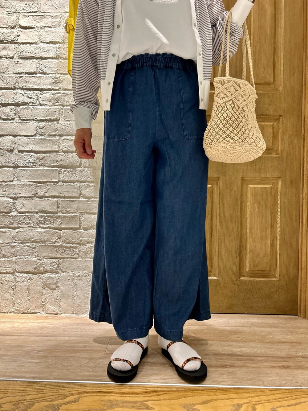 ホワイト系のTシャツ/カットソー、ブルー系のその他パンツ、ホワイト系のトートバッグを着用したレディースの夏コーディネートの3枚目の写真