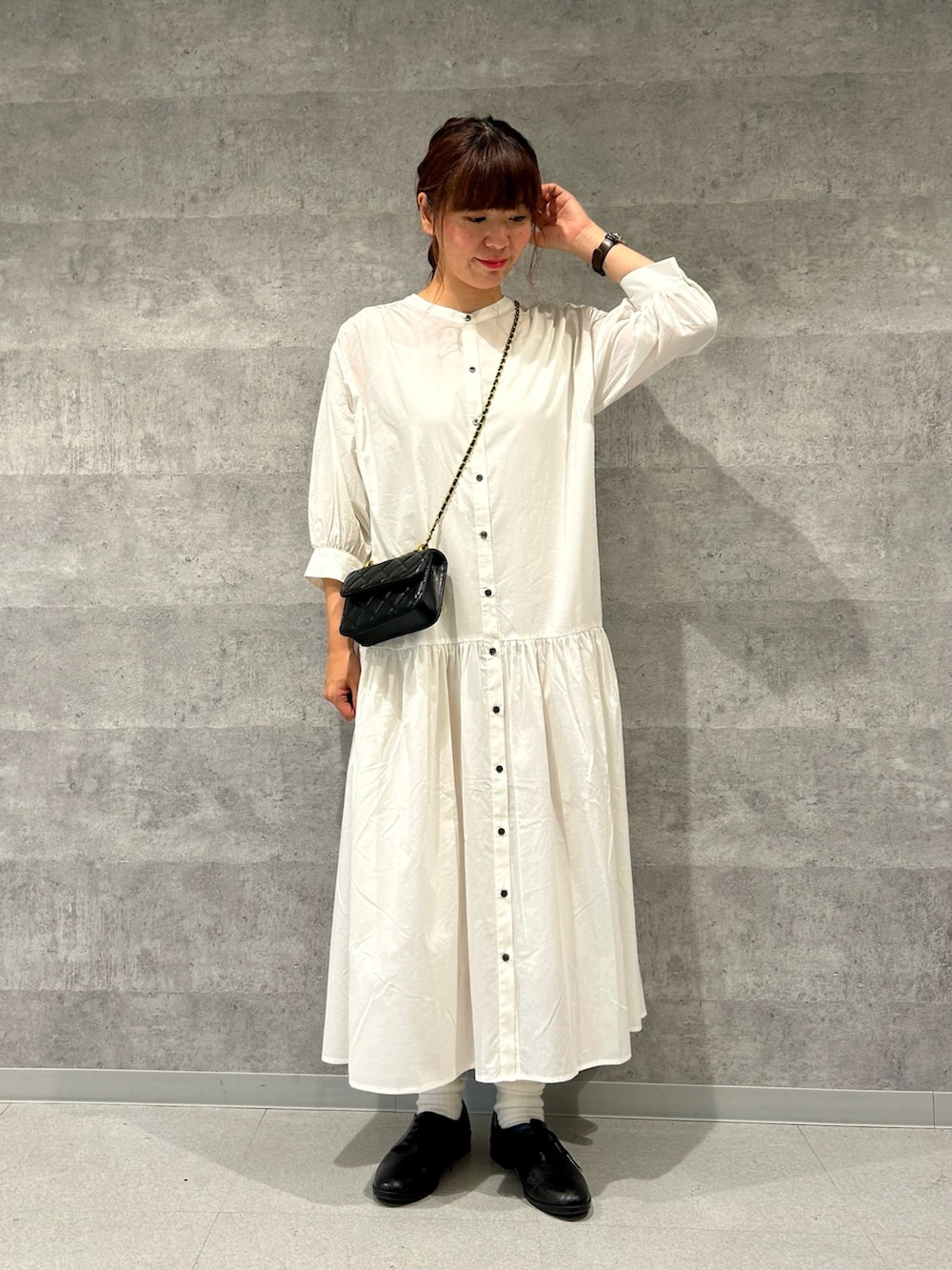 ブルー系のテーラードジャケット、ブラック系のショルダーバッグ、ホワイト系のシャツワンピースを着用したレディースの春コーディネートの3枚目の写真