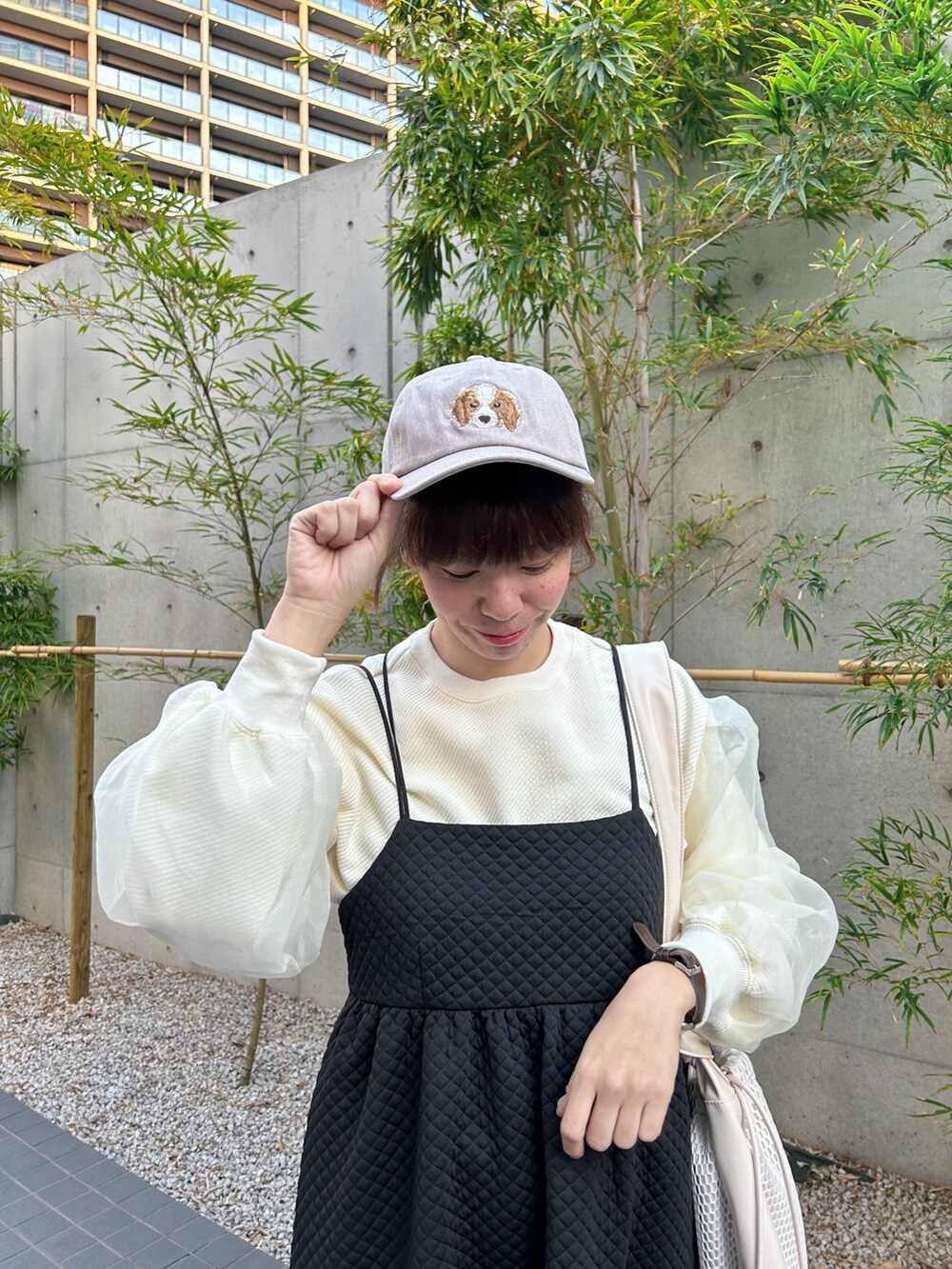 ホワイト系のショルダーバッグ、ブラック系のワンピース、ホワイト系のTシャツ/カットソーを着用したレディースの冬コーディネートの3枚目の写真