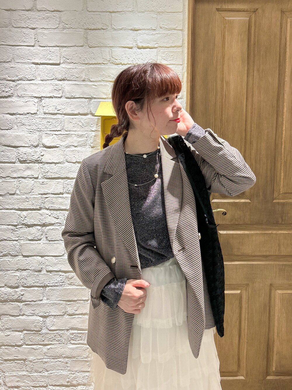 ホワイト系のスカート、ブラック系のTシャツ/カットソー、ベージュ系のテーラードジャケットを着用したレディースの冬コーディネートの2枚目の写真