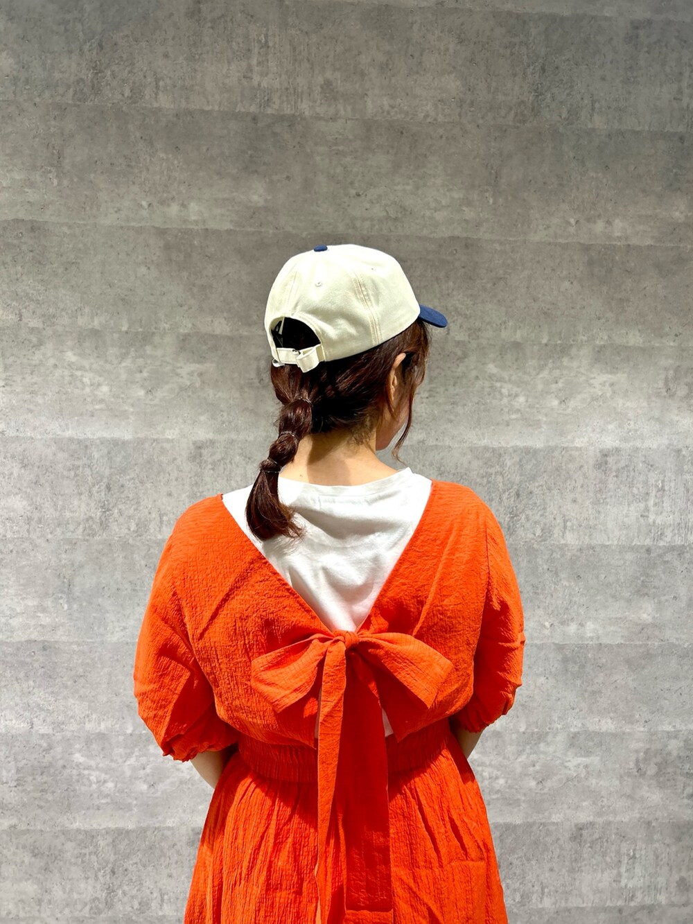 ホワイト系のTシャツ/カットソー、オレンジ系のワンピース、オレンジ系のかごバッグを着用したレディースの夏コーディネートの2枚目の写真