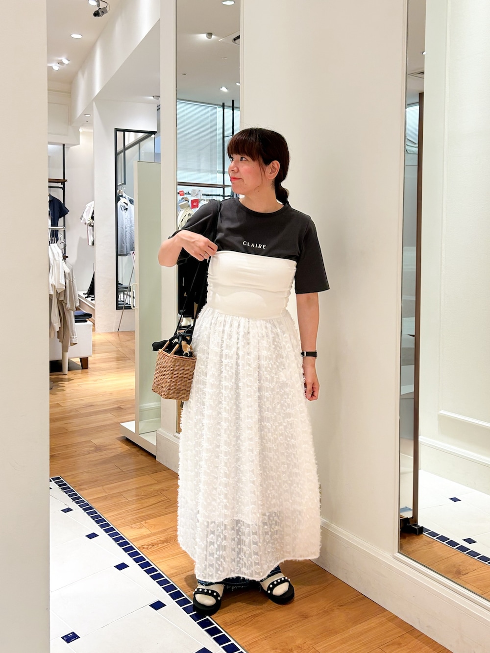 イエロー系のかごバッグ、グレー系のTシャツ/カットソー、ホワイト系のワンピースを着用したレディースの夏コーディネートの2枚目の写真