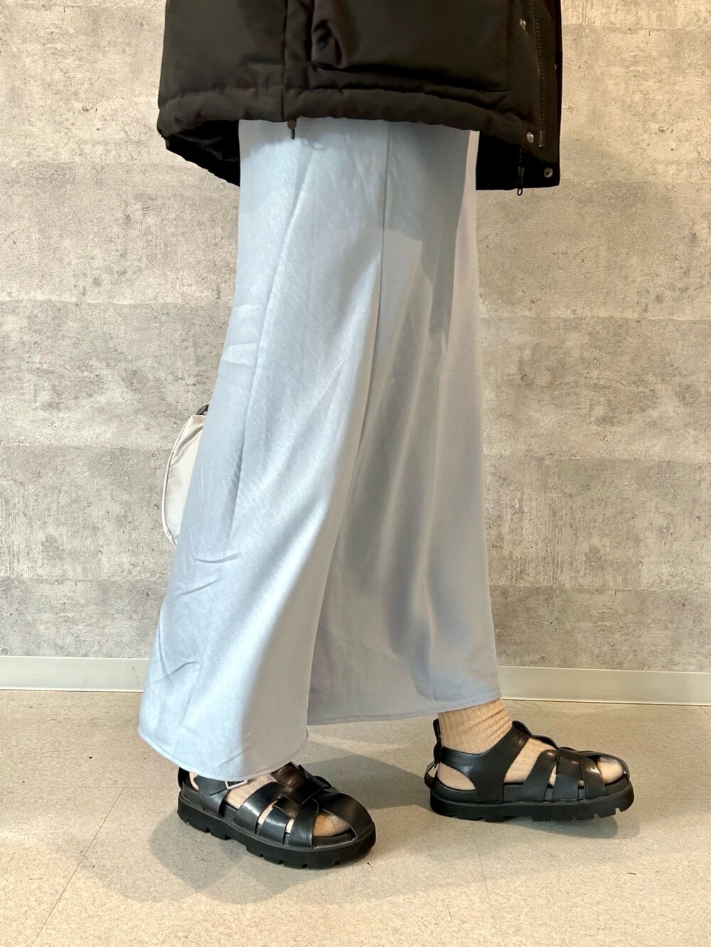 ブラック系のダウンジャケット/コート、グレー系のショルダーバッグ、ホワイト系のTシャツ/カットソーを着用したレディースの秋コーディネートの3枚目の写真