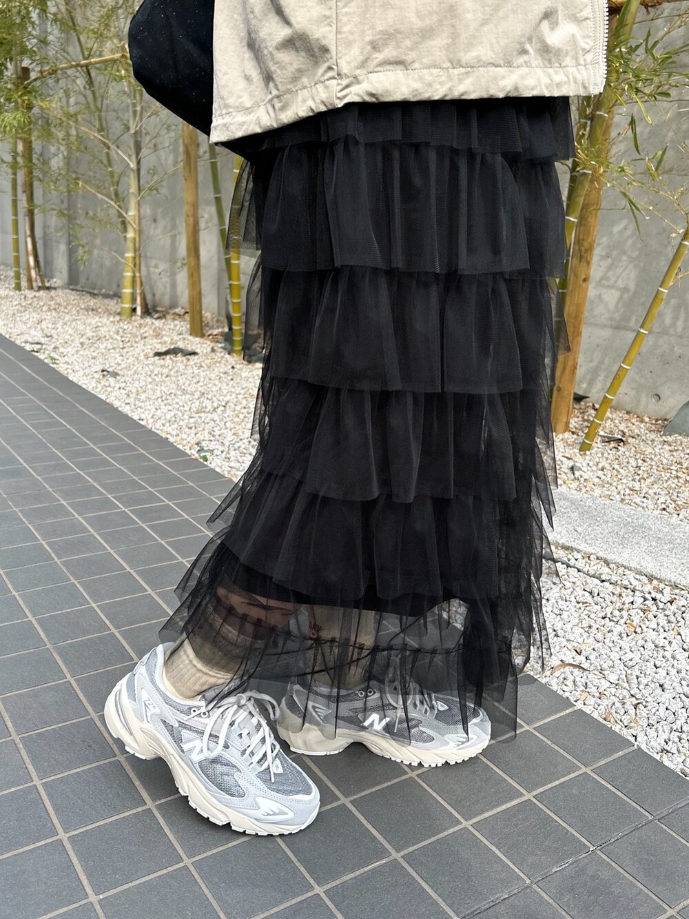 ベージュ系のテーラードジャケット、グレー系のスウェット、ブラック系のスカートを着用したレディースの春コーディネートの3枚目の写真