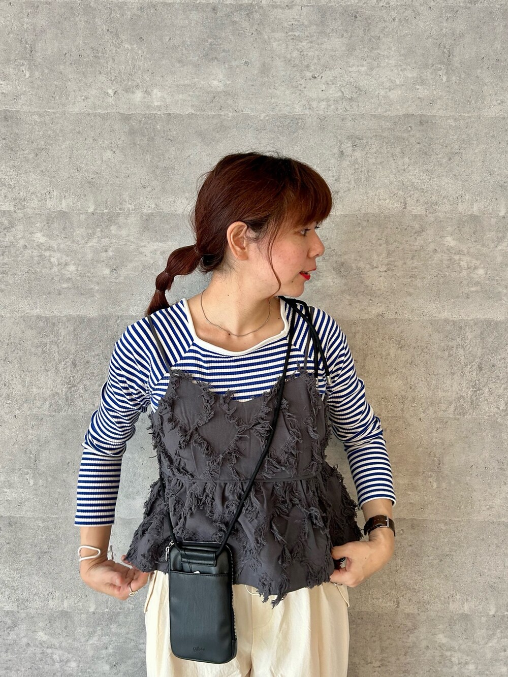 ブラック系のショルダーバッグ、ホワイト系のその他パンツ、グレー系のシャツ/ブラウスを着用したレディースの春コーディネートの2枚目の写真