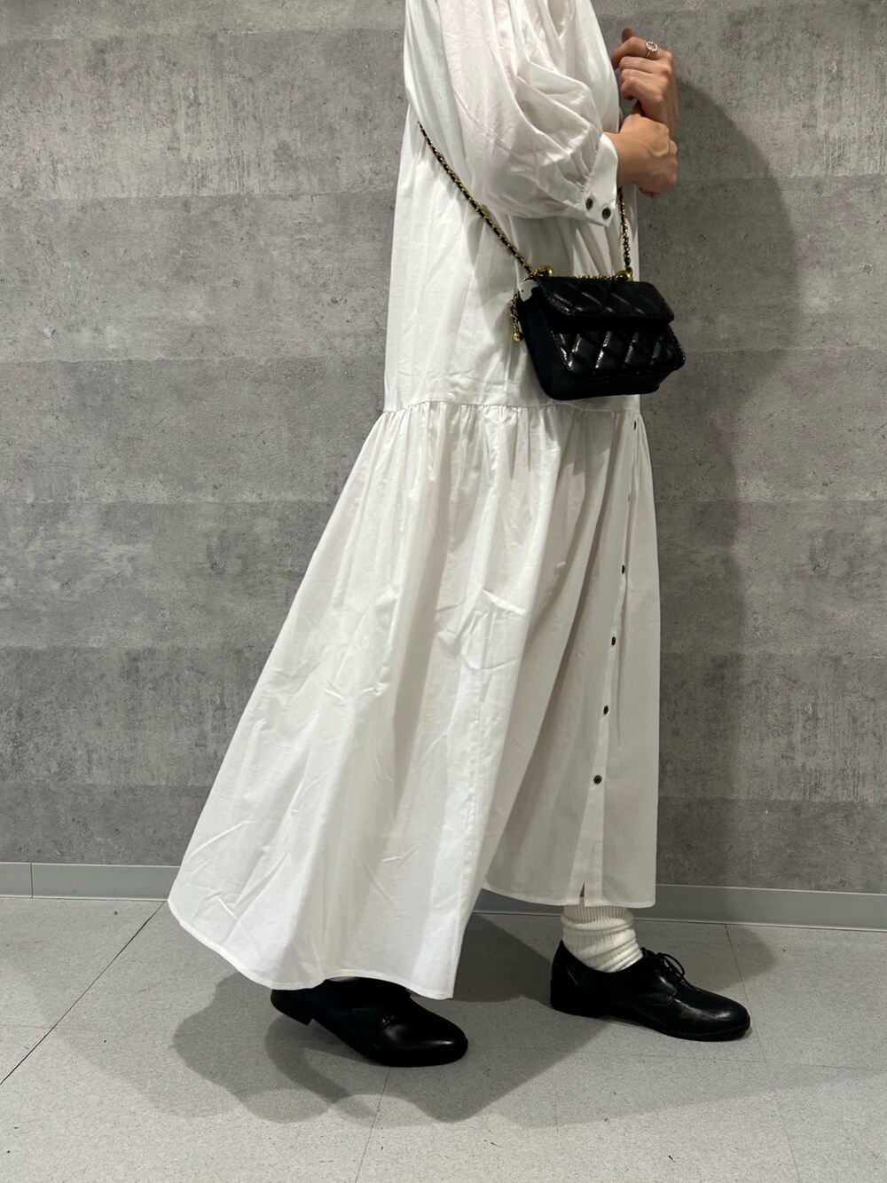 ブルー系のテーラードジャケット、ブラック系のショルダーバッグ、ホワイト系のシャツワンピースを着用したレディースの春コーディネートの4枚目の写真