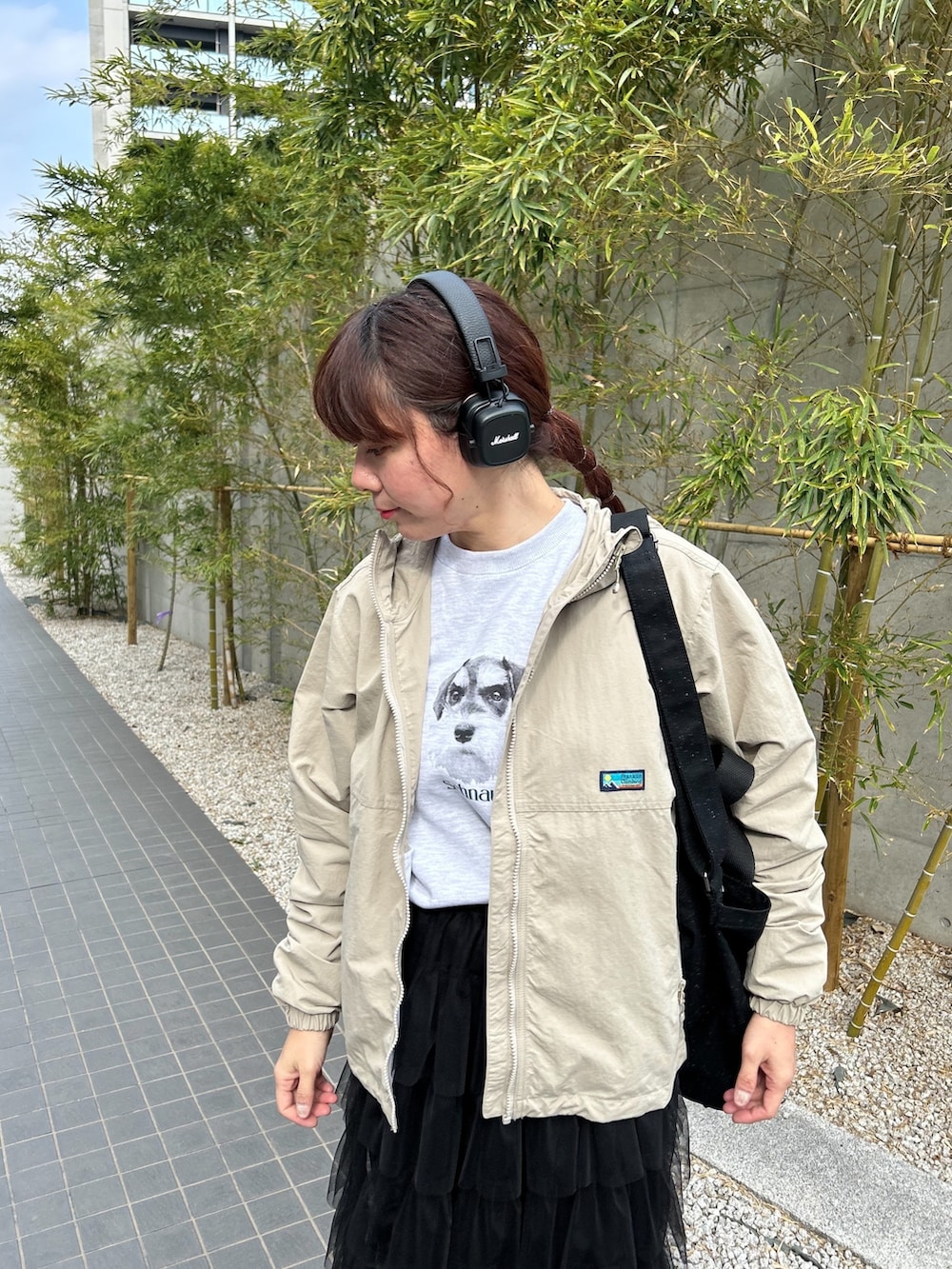 グレー系のマウンテンパーカー、グレー系のスウェット、ブラック系のショルダーバッグを着用したレディースの春コーディネートの2枚目の写真