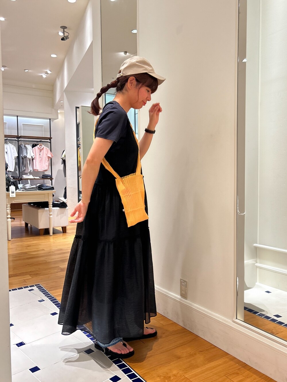 ブルー系のTシャツ/カットソー、ブラック系のワンピース、ブルー系のデニムパンツを着用したレディースの夏コーディネートの2枚目の写真