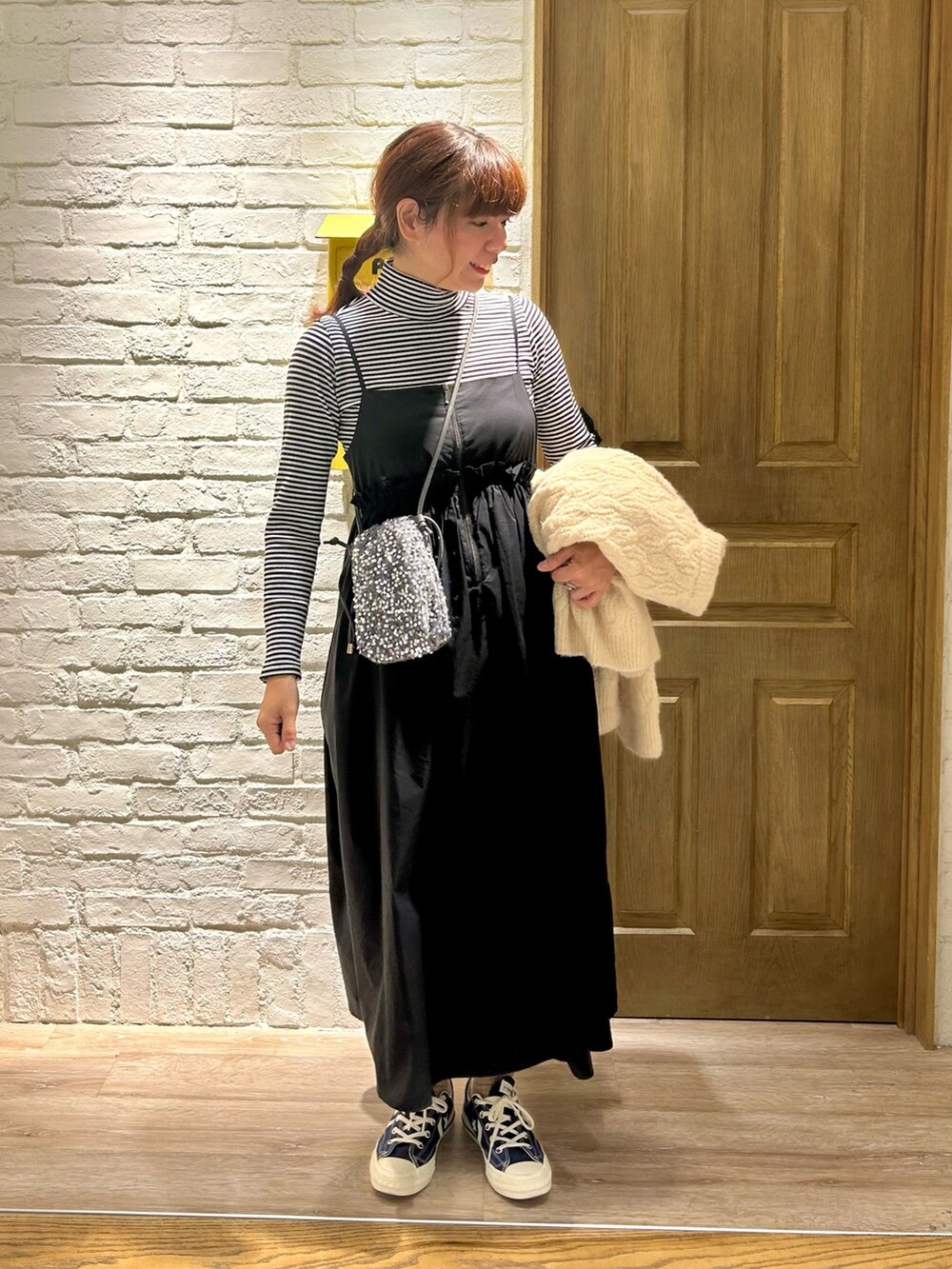 ホワイト系のカーディガン/ボレロ、ホワイト系のTシャツ/カットソー、ブラック系のワンピースを着用したレディースの秋コーディネートの4枚目の写真